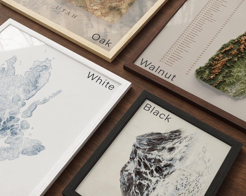 four framed artworks, each with a different color and style, arranged on a wooden surface.