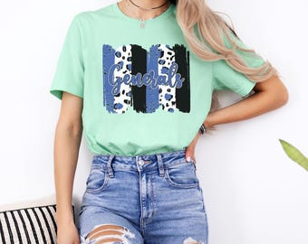 May include: A light green short-sleeve t-shirt featuring a central graphic design. The graphic consists of vertical brushstroke patterns in black, blue, and white leopard print, with the word "Generals" written in a blue cursive script font.