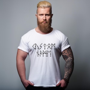 Puede incluir: Camiseta blanca con un gr&aacute;fico negro de la palabra "CUSTOM" escrita en runas.