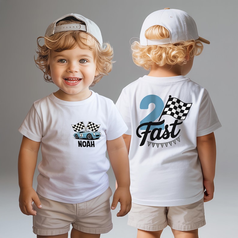 A smiling young boy wearing a white t-shirt with a race car design and the text "Noah 2 Fast" on the back.