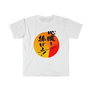 Pode incluir: Camiseta branca com um gráfico circular vermelho e amarelo. O círculo contém texto japonês que se lê "心" e "捧" e o texto em inglês "Devote Your Heart!"