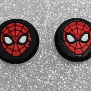 May include: Two black and red Spider-Man face controller thumb grips.