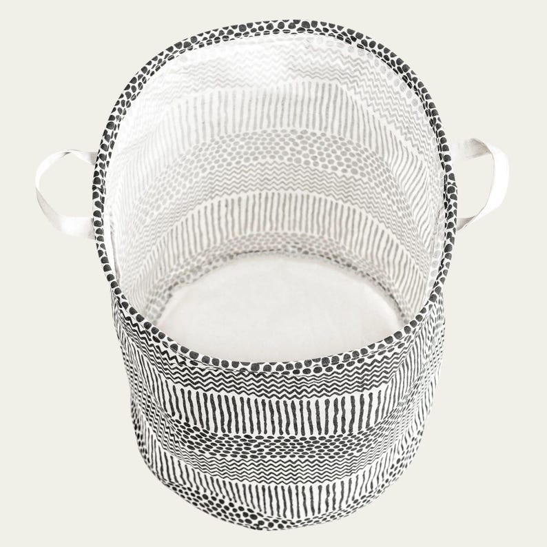 May include: A black and white patterned fabric storage bin with two handles. The bin is empty and has a white interior.