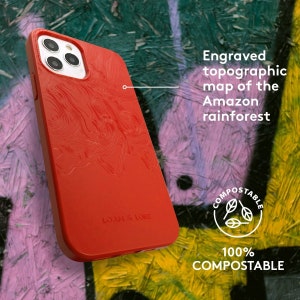 May include: A red phone case with an engraved topographic map of the Amazon rainforest. The case is labeled "LOAN & LORE" and is marked as 100% compostable.