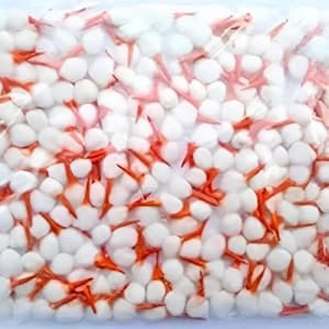 May include: A close-up view of a plastic bag filled with white cotton balls with orange stems. The cotton balls are arranged in a random pattern.