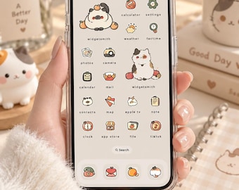 May include: A smartphone with a clear protective case displaying a custom home screen interface. The screen features a light cream background with various app icons and widgets illustrated with small cartoon cats, fruits, and soft-toned graphics.