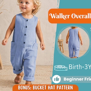 以下が含まれることがあります： 子供用のライトブルーのウォーカーオーバーオールジャンプスーツ。ボタン留めのフロント、ポケット、折り返しの袖口が特徴です。画像には、この衣装を着た子供が写っています。画像には「Birth-3Y」と「Beginner Friendly」と書かれています。