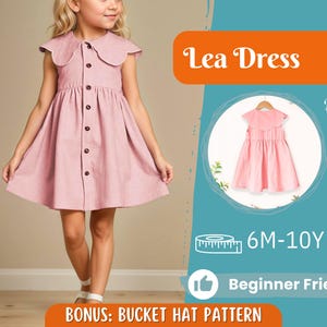 Op de afbeelding: Een roze jurk met een Peter Pan kraag en een knoopsluiting aan de voorkant. De jurk wordt getoond op een jong meisje. De afbeelding bevat ook een achteraanzicht van de jurk, de tekst "Lea Dress" en de tekst "Beginner Friendly".