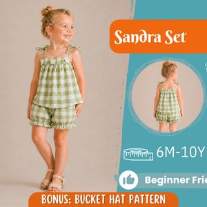 Peut inclure: Une jeune fille porte un ensemble deux pièces à carreaux verts et blancs, comprenant un haut avec des détails floraux et un short assorti. L'image contient le texte "Sandra Set" et "Beginner Friendly". L'ensemble est conçu pour les tailles 6 mois à 10 ans.