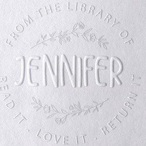 Puede incluir: Sello en relieve blanco con el texto "From the Library of Jennifer Read it. Love it. Return it." y un dise&ntilde;o floral.