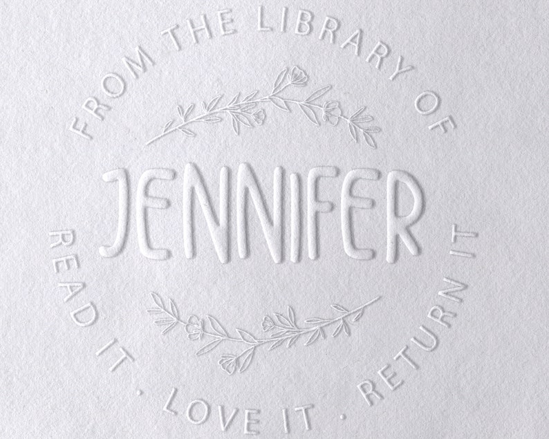Puede incluir: Sello en relieve blanco con el texto "From the Library of Jennifer Read it. Love it. Return it." y un dise&ntilde;o floral.
