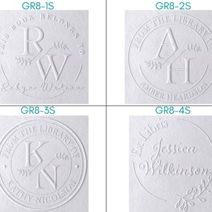 Puede incluir: Cuatro ex libris blancos en relieve con diferentes nombres e iniciales. Los ex libris son circulares y presentan una peque&ntilde;a rama de hojas. El texto en los ex libris dice: "Este libro pertenece a Robyn Watson", "De la biblioteca de Amber Heardson", "De la biblioteca de Kathy Nicolson" y "Ex Libris Jessica Wilkinson".