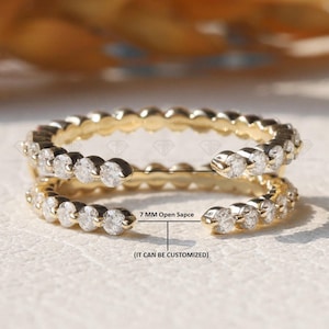 Puede incluir: Un anillo de oro con una doble fila de pequeños diamantes. El anillo está abierto por un lado y tiene un espacio abierto de 7 mm. El texto "(IT CAN BE CUSTOMIZED)" está impreso debajo de la medida.