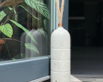 Hoge betonnen deurstopper met handvat van koper en touw