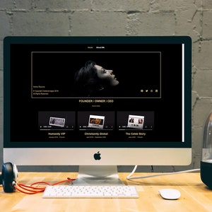 Puede incluir: Una pantalla de ordenador que muestra un sitio web con fondo negro y texto dorado. El sitio web presenta una foto de una mujer con cabello oscuro y un vestido negro. El texto en la pantalla dice "Fundador | Propietario | CEO". Hay tres miniaturas de video debajo de la foto, cada una con un t&iacute;tulo: "Humanity VIP", "Christianity Global" y "The Celeb Story".