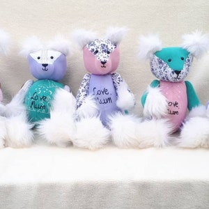 May include: Five handmade patchwork teddy bears with white fur. Each bear has a different color combination and features the text "Love Mum" or "Love, Mum".