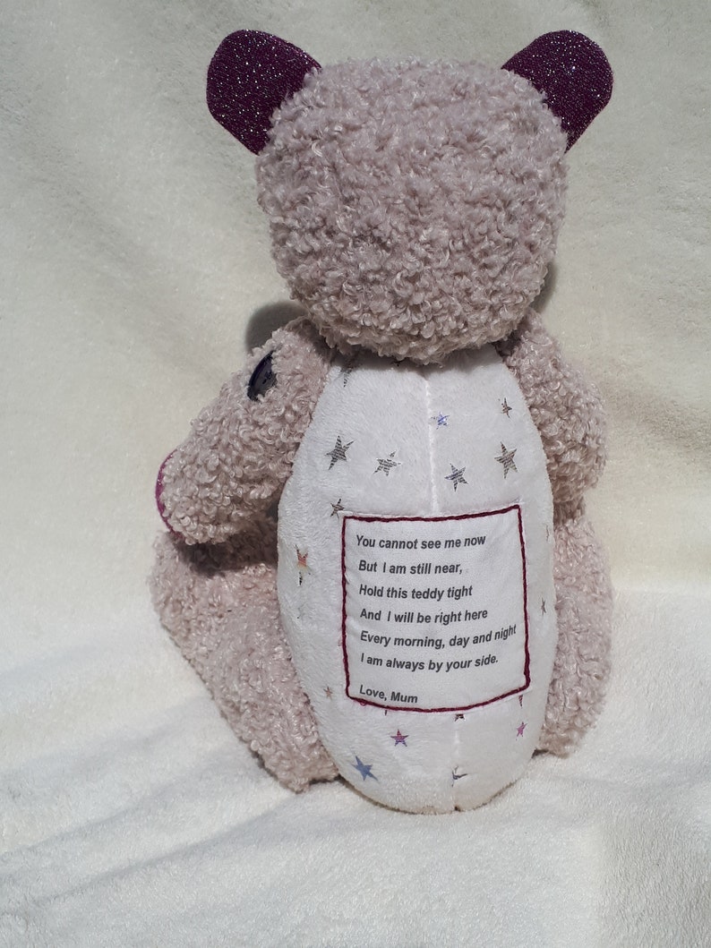 May include: A plush, light brown teddy bear with a white embroidered heart on its chest. The heart has a message that reads: "You cannot see me now But I am still near, Hold this teddy tight And I will be right here Every morning, day and night I am always by your side. Love, Mum".