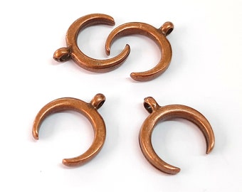 May include: Four copper crescent moon charms with a loop at the top for attaching to jewellery or other crafts.