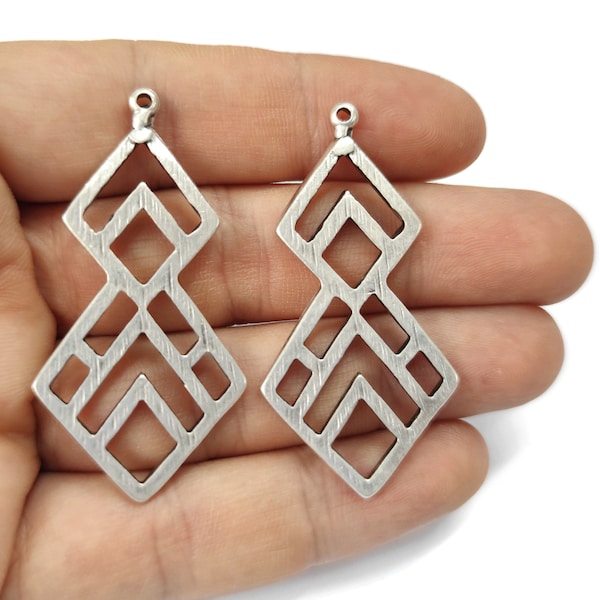 May include: Two silver geometric pendant charms with a diamond shape and a textured surface. The charms have a hole at the top for attaching to jewellery.