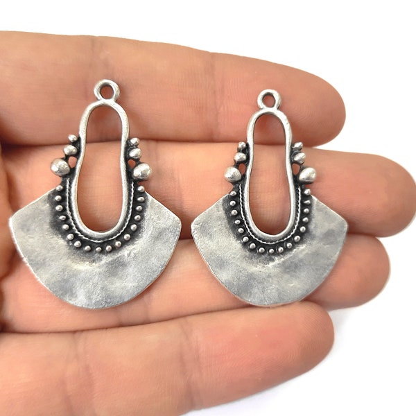 May include: Two silver-toned metal earring blanks with a fan-shaped design and a decorative oval opening. The blanks have a textured finish and are ready to be customised.