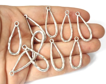Puede incluir: Diez piezas en blanco para pendientes de metal plateado en forma de lágrima con textura martillada. Las piezas en blanco tienen un bucle en la parte superior para sujetar los alambres de los pendientes.
