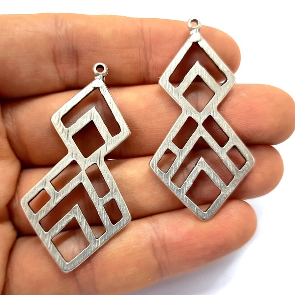 May include: Two silver geometric pendant charms with a textured surface and a hole at the top for hanging.