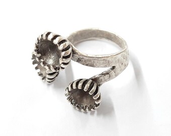 May include: A silver-toned ring with a unique design. The ring features three textured, cup-shaped elements with ridged edges. The band has a hammered texture, adding to its handcrafted appearance. The ring is set against a white background.