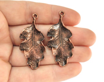 May include: Two copper-coloured oak leaf charms with a loop at the top for hanging. The leaves have a textured surface and are approximately 5 cm long.