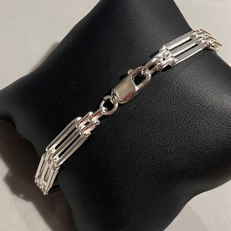Peut inclure: Un bracelet en argent avec un fermoir &agrave; bo&icirc;te. Le bracelet est compos&eacute; de plusieurs brins de cha&icirc;ne.
