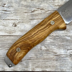 Pu&ograve; includere: Un coltello con manico in legno e lama in acciaio inossidabile. Il manico &egrave; in legno di ulivo e presenta due accenti metallici decorativi. La lama &egrave; incisa con le parole "Goldenhorn" e "Made in Germany".