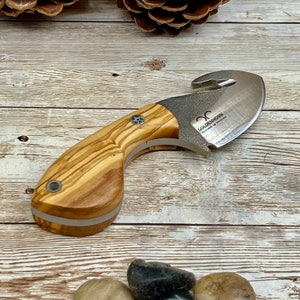 May include: A small, silver knife with a wooden handle. The blade has a serrated edge and a hook on the end. The handle is made of olive wood and has a white inlay. The knife is made by Goldenhorn.