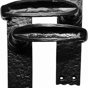 May include: Black, wrought iron door handles with a textured finish. The handles have a curved, ergonomic design and are mounted on rectangular backplates. The hardware is designed for durability and a classic aesthetic.