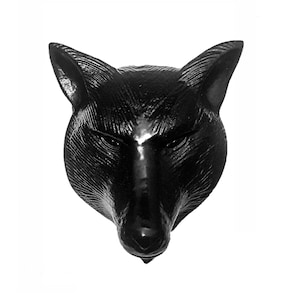 May include: Black wolf head sculpture with a detailed, textured surface. The wolf's head is facing forward with its mouth closed.