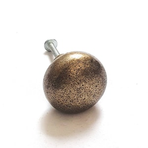 Peut inclure: Un bouton de porte rond en or texturé avec une vis argentée.