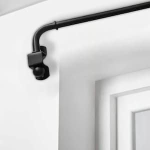 Könnte beinhalten: Schwarze Gardinenstange aus Metall mit einem gebogenen Ende und einer Kugel als Abschluss. Die Stange ist an einer weißen Wand montiert und erstreckt sich über ein Fenster.