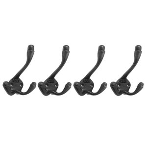 May include: Set of four black cast iron hooks with a double hook design. Each hook has a rounded top and a small decorative detail on the base.