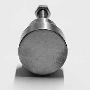 Puede incluir: Un pomo redondo plateado con un tornillo roscado. El pomo tiene un acabado cepillado.