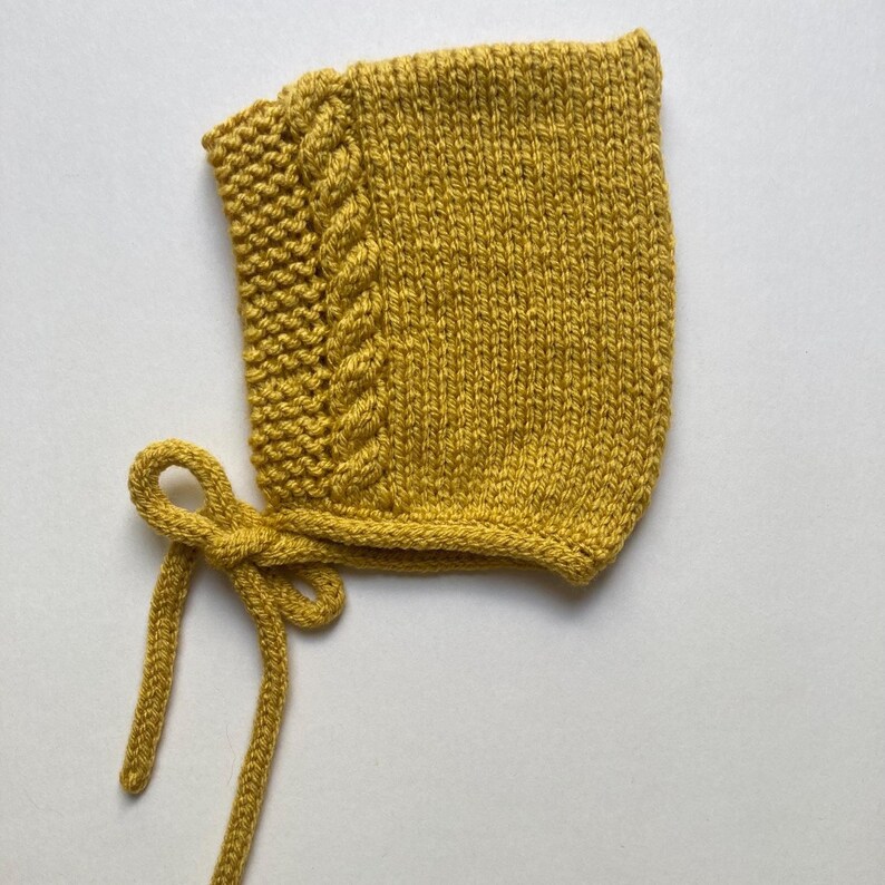 Puede incluir: Gorro de beb&eacute; tejido de color amarillo mostaza con un dise&ntilde;o de trenza en el lateral. El gorro tiene un cierre de lazo. El gorro de punto est&aacute; hecho de hilo suave y es un accesorio acogedor para reci&eacute;n nacidos y beb&eacute;s.