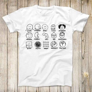 Puede incluir: Camiseta blanca con dibujos de línea negra de artistas famosos y sus estilos de firma. Los artistas incluyen Da Vinci, Rembrandt, Monet, Munch, Velázquez, Van Gogh, Picasso, Dalí, Bob Ross, Miguel Ángel, Rothko, Pollock, Warhol, Kandinsky y Paul Klee.