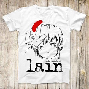 May include: White t-shirt featuring a black and red graphic of an anime character with the text "lain serial experiments". The design includes a hand with a red shape and the character's face.