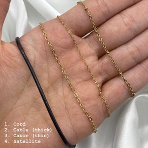 May include: Image showing four necklace chain styles: a black cord, a thick cable chain, a thin cable chain, and a satellite chain. The chains are gold-coloured and displayed against a white background. Text labels each chain style.