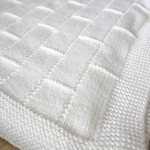 May include: White knitted blanket with a square pattern.