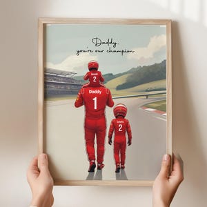 May include: A framed print featuring a race car driver in a red suit with the number 1, carrying a child in a red suit with the number 2 on their shoulders, and another child in a red suit with the number 2, with the text Daddy, you're our champion.