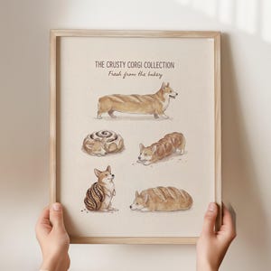 May include: A framed print titled "The Crusty Corgi Collection" featuring watercolor illustrations of corgis and baked goods. The corgis are depicted in various poses, resembling bread loaves and pastries. The print has a light beige background and a wooden frame.