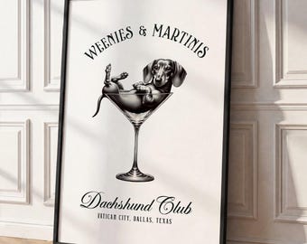 May include: A black and white framed wall art print featuring a dachshund resting inside a martini glass. The text reads WEENIES & MARTINIS, Dachshund Club, and VATICAN CITY, DALLAS, TEXAS. The illustration is centered on a white background.