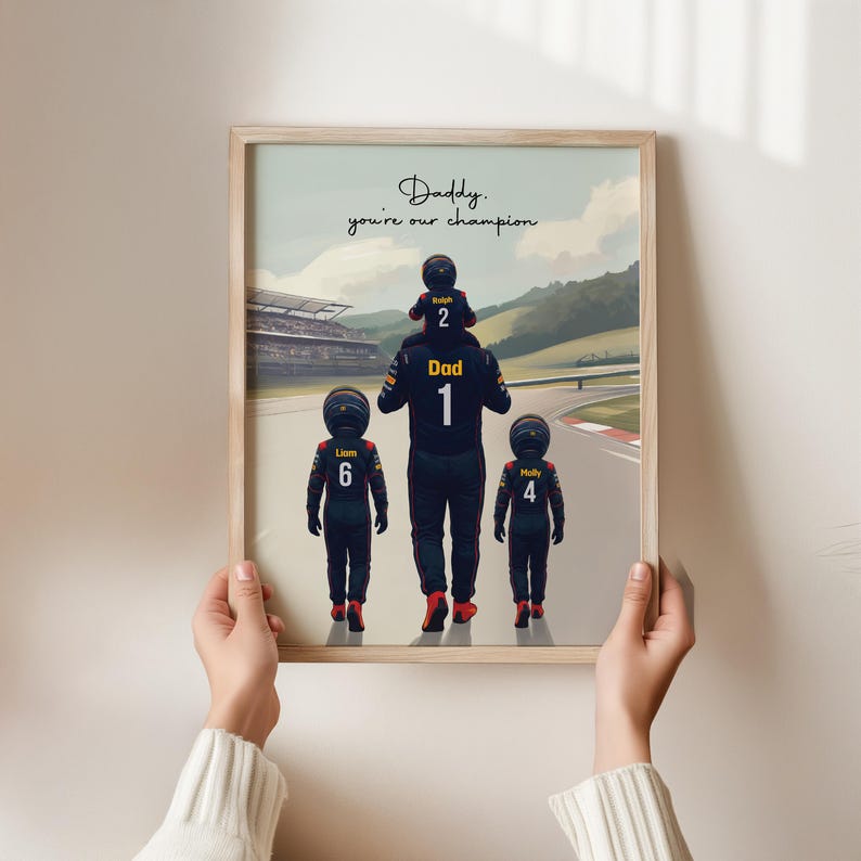 May include: A framed art print featuring a cartoon illustration of a parent in a racing suit labeled Dad 1, carrying a child labeled Ralph 2 on their shoulders, with two other children labeled Liam 6 and Molly 4. Text reads: Daddy, you're our champion.