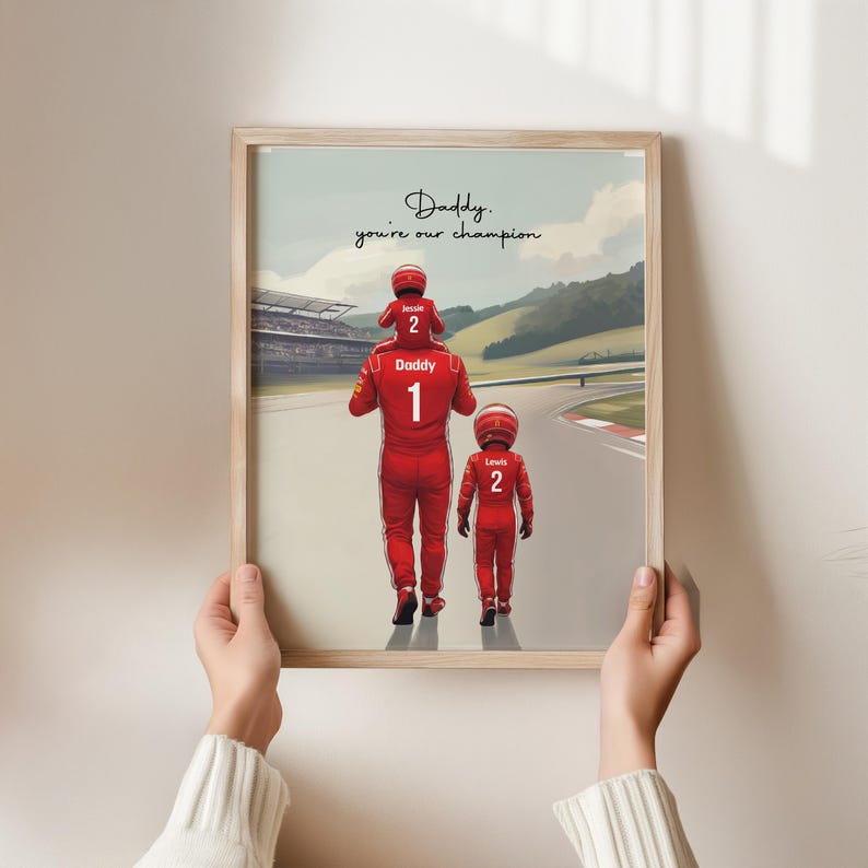 May include: A framed print featuring a race car driver in a red suit with the number 1, carrying a child in a red suit with the number 2 on their shoulders, and another child in a red suit with the number 2, with the text Daddy, you're our champion.