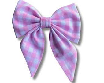 Op de afbeelding: Een roze en witte gingham strik met puntige uiteinden.