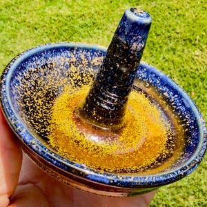 Handmade ceramic ring holder featuring flowing glaze and natural color variation, pottery jewelry holder with glossy surface and unique finish.