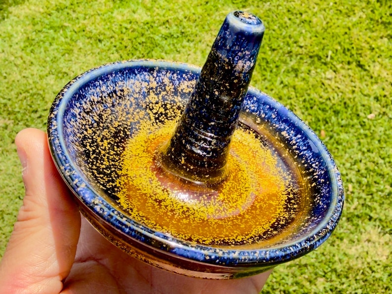Handmade ceramic ring holder featuring flowing glaze and natural color variation, pottery jewelry holder with glossy surface and unique finish.